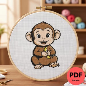 May include: A cross-stitch design of a cartoon monkey with a banana, set in a wooden embroidery hoop. The monkey is brown with a tan face and ears. The text "PDF Pattern" is in a red circle.