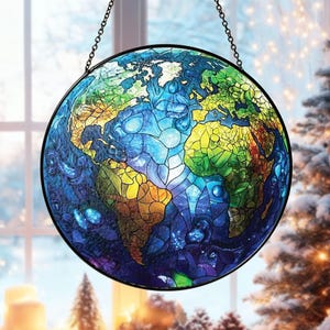 May include: A round stained glass window depicting the Earth, with continents in shades of green, yellow, and brown, surrounded by blue oceans. The window is framed in black and hangs from a chain. The design is reminiscent of a map.