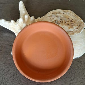 May include: A set of three ceramic nesting bowls in shades of blue, green, and white. The bowls feature a speckled design and are graduated in size, with the largest measuring approximately 6 inches in diameter.