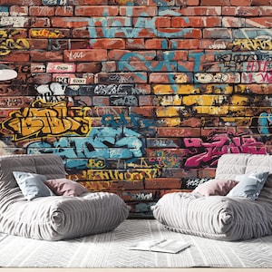 A detailed textured red brick wall covered in layered urban graffiti art, featuring colorful spray paint tags in shades of turquoise blue, bright yellow, pink, black, and white.