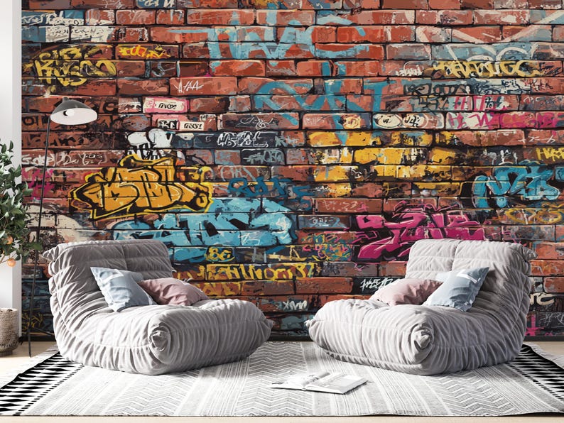 A detailed textured red brick wall covered in layered urban graffiti art, featuring colorful spray paint tags in shades of turquoise blue, bright yellow, pink, black, and white.