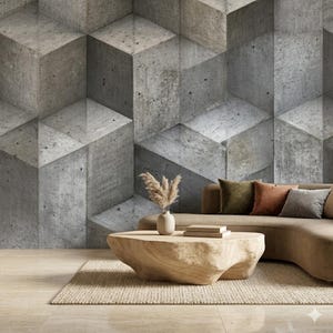 May include: A modern living room featuring a geometric concrete wall design. A light brown sofa with colorful pillows, a wooden coffee table, and a beige rug complete the space. A vase with dried plants adds a natural touch.