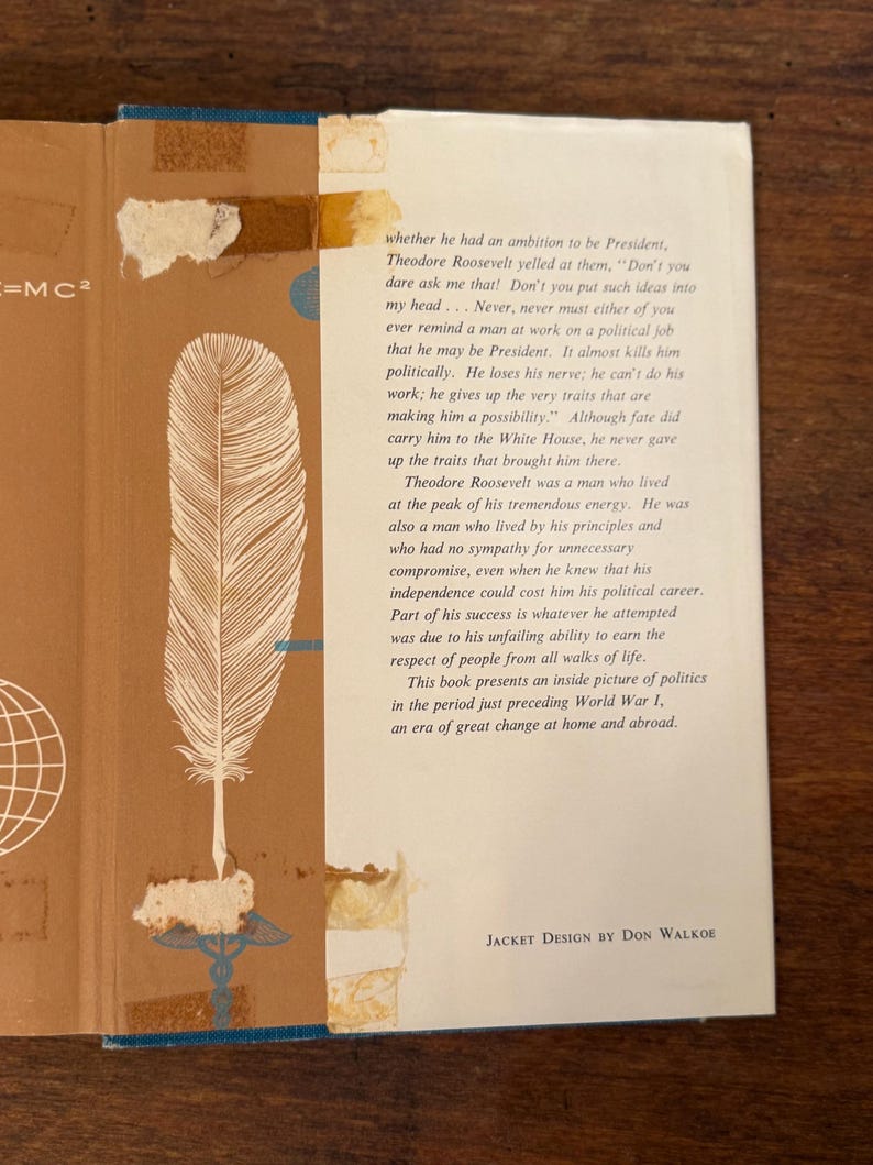 May include: A vintage book cover with a tan and white design. The cover features a large feather illustration and text from the book. The text includes the phrase "JACKET DESIGN BY DON WALKOE".