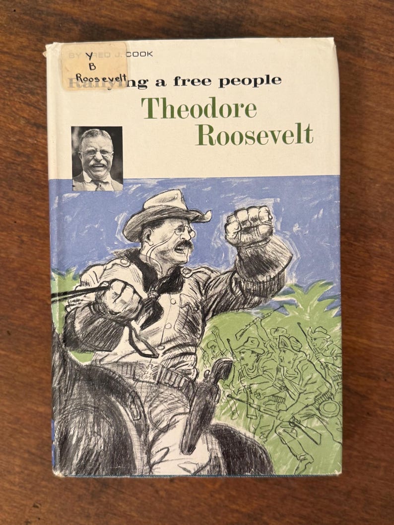 May include: A vintage book cover with an illustration of Theodore Roosevelt on horseback, raising his fist. The title reads "Roosevelt: A Free People" with the author's name below. The cover has a blue and green background.