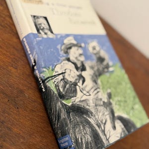 May include: A vintage book titled "Rallying to Free People" by Theodore Roosevelt. The cover features an illustration of a man on horseback, with blue and green accents. Published by Kingston House Lippincott.