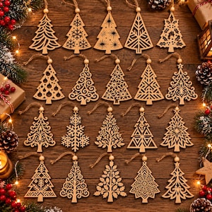 May include: A collection of twenty laser-cut wooden Christmas tree ornaments arranged in four rows. Each ornament features a unique intricate cutout pattern, including snowflakes, geometric shapes, and floral motifs, suspended by a thin twine loop.