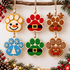 May include: Six wooden paw-shaped Christmas ornaments hanging from a branch. Designs include a snowman, a red Santa suit, a brown reindeer, a blue snowflake and tree pattern, a green elf suit, and a brown gingerbread face with a red bow tie.