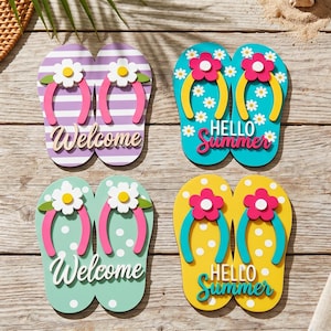 Könnte beinhalten: Vier Paare dekorativer Wanddekorationen in Flip-Flop-Form. Ein Paar zeigt violette Streifen mit weißen Blumen und dem Wort Welcome. Ein weiteres ist türkis mit weißen Gänseblümchen und Hello Summer. Ein drittes ist mintfarben mit weißen Punkten und Welcome. Das letzte ist gelb mit weißen Punkten und Hello Summer.