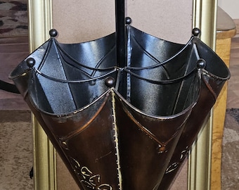 Paragüero vintage de metal repujado con motivos florales y una encantadora pátina.