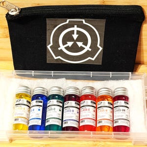 Peut inclure: Une pochette zippée noire avec un logo SCP Foundation blanc, accompagnée d'un étui de rangement en plastique transparent contenant sept petits flacons en verre remplis de liquides colorés, étiquetés avec les classes SCP de A à UN.