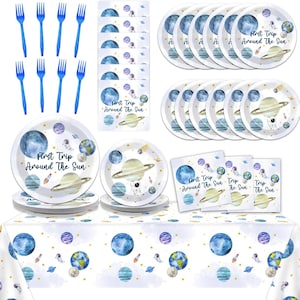 May include: A space-themed party set featuring plates, napkins, and a tablecloth with planets, astronauts, and rockets. The plates and napkins have the text "First Trip Around The Sun". Blue plastic forks are also included, creating a cohesive party theme.