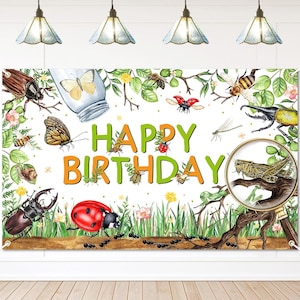 May include: A white banner with a colorful illustration of various insects, flowers, and greenery. The words "HAPPY BIRTHDAY" are written in green and orange. A magnifying glass shows a grasshopper. Decorative banner for a birthday party.
