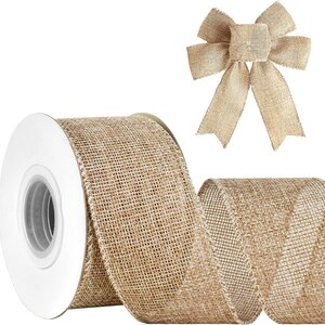 May include: A spool of tan burlap ribbon with a woven texture and finished edges, accompanied by a pre-tied decorative bow made from the same natural-colored fabric. The ribbon is wound around a white plastic core with a circular center opening.
