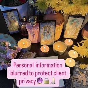 May include: A still life arrangement featuring tarot cards, lit candles, and a pink perfume bottle. The scene includes yellow flowers and a decorative plate. Text on a pink banner reads "Personal information blurred to protect client privacy."