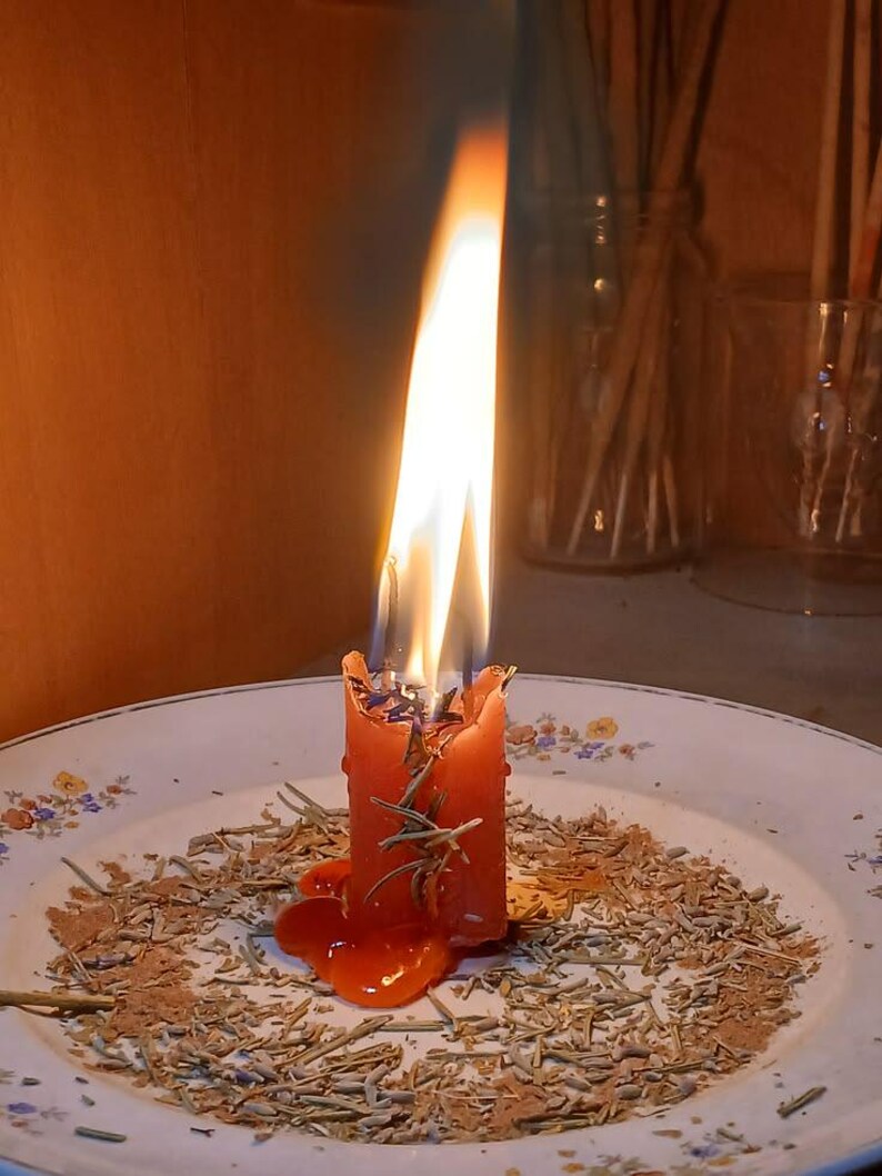 A single lit candle on a plate, with a warm glow and smoke rising from it, creating a cozy and intimate atmosphere.