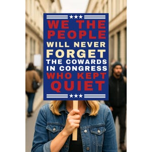 May include: A person holding a sign with the text "WE THE PEOPLE WILL NEVER FORGET THE COWARDS IN CONGRESS WHO KEPT QUIET." The sign is blue with white and red lettering and three stars at the top and bottom.