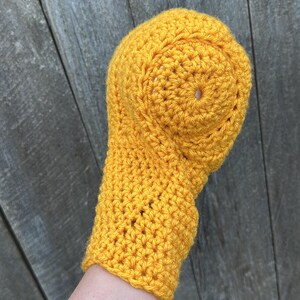 Puede incluir: Un conjunto de gorro y mit&oacute;n de ganchillo amarillo brillante, hecho a mano. El gorro tiene una parte superior redondeada con un peque&ntilde;o agujero, y el mit&oacute;n est&aacute; adjunto. El conjunto est&aacute; hecho de hilo texturizado.