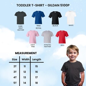 Op de afbeelding: Een selectie van peuter-T-shirts in verschillende kleuren, waaronder donkergrijs, koningsblauw, zwart, wit, lichtroze, athletic heather en rood. De afbeelding toont ook een maattabel met afmetingen in centimeters voor breedte en lengte.