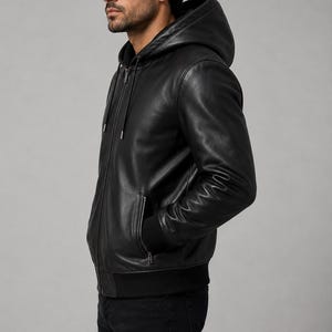 Side view of black leather hooded jacket showing fitted silhouette and sleeve details