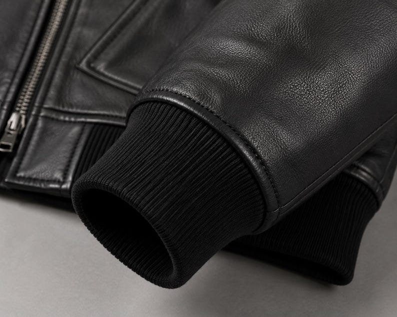 Close-up of ribbed cuff and genuine leather sleeve on black hooded jacket