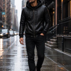 Man wearing a black leather hooded jacket in a casual urban setting