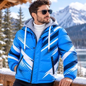 Könnte beinhalten: Eine leuchtend blaue Steppjacke mit einem abstrakten grafischen Muster in Weiß und Dunkelblau, einer grauen Kapuze mit weißen Kordelzügen, einem hohen weißen Rollkragen und schwarzen Reißverschlusstaschen, getragen mit einer dunklen Sonnenbrille.