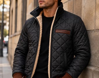 May include: A black quilted jacket featuring a beige sherpa lining, a high collar, and a front zipper closure. The jacket includes brown ribbed cuffs and a brown leather-like chest pocket detail, worn over a black shirt and black pants.