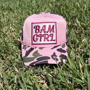 Op de afbeelding: Een witte keramische mok met een zwarte handgreep en de tekst "But First, Coffee" in een vetgedrukte, zwarte letter. De mok staat tegen een vage achtergrond. De mok is ongeveer 10 cm hoog.