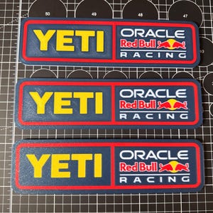 Könnte beinhalten: Eine weiße Keramik-Tasse mit schwarzem Henkel und dem Text "But First, Coffee" in schwarzer, handschriftlicher Schrift. Die Tasse steht auf einer weißen Oberfläche.