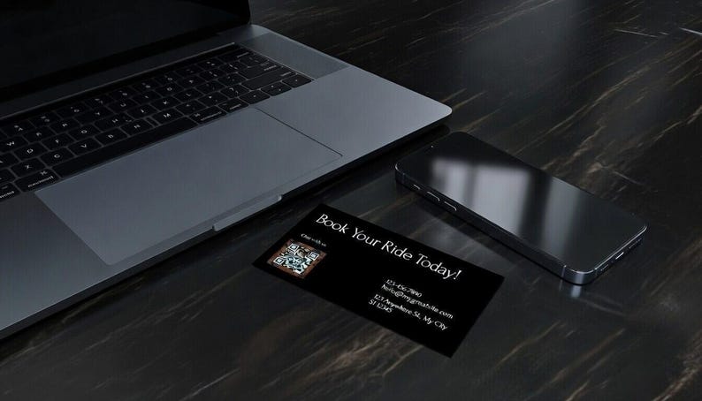 May include: A laptop, smartphone, and business card are arranged on a dark, textured surface. The business card, with the text "Book Your Ride Today!", includes a QR code and contact information. The smartphone is black and sleek.