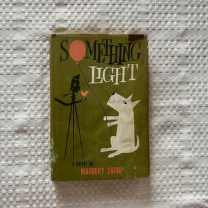 May include: Vintage book cover for "Something Light" by Margery Sharp. The cover features a whimsical illustration of a dog holding a balloon, a camera on a tripod, and a bird, all set against a green background. The title is in large, bold letters.