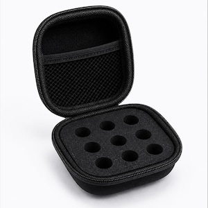 Peut inclure: Étui de transport noir carré à fermeture éclair, ouvert pour révéler un insert en mousse avec sept découpes circulaires. L'étui a une poche en filet à l'intérieur du couvercle. Le texte "BE BETTER PEPTIDES" est imprimé en haut.