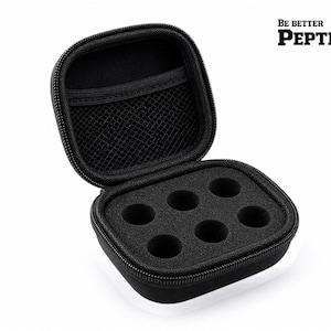 Puede incluir: Estuche de transporte con cremallera en blanco y negro abierto, con un inserto de espuma con seis recortes circulares. El estuche tiene un bolsillo de malla negro en el interior de la tapa. El texto "BE BETTER PEPTIDES" está impreso en la parte superior derecha.