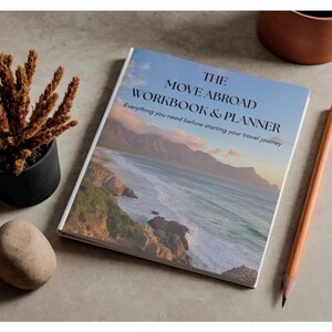 Könnte beinhalten: Ein rechteckiges Arbeitsbuch und Planer mit dem Titel THE MOVE ABROAD WORKBOOK & PLANNER: Everything you need before starting your travel journey. Das Cover zeigt ein landschaftliches Foto einer Küste mit Bergen und Meer.
