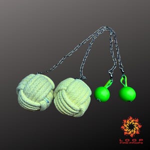Puede incluir: Conjunto de accesorios de fuego con dos bolas grandes anudadas de color amarillo claro conectadas por una cadena plateada a dos bolas pequeñas de color verde brillante. Accesorios de rendimiento.