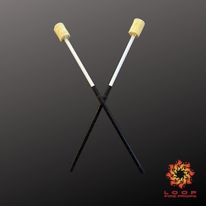 May include: Two fire spinning props crossed against a dark background. Each prop has a white shaft, a black grip, and a flame-resistant wick at the top. The logo "LOOP FIRE PROPS" is in the bottom right corner.