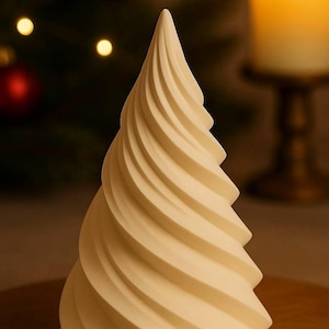 Può includere: Decorazione per albero di Natale a forma di spirale color crema. L'albero ha una superficie strutturata e una forma conica. Lo sfondo include un albero di Natale sfocato e una candela accesa.