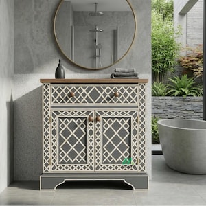 Könnte beinhalten: Ein grauer Badezimmer-Waschtisch mit einem geometrischen cremefarbenen Muster. Er hat zwei Türen und eine Schublade, mit Holzknöpfen und einer Holzplatte. Ein runder Spiegel hängt darüber. Das Badezimmer hat ein modernes Design mit Badewanne.