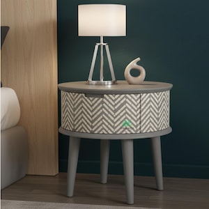 Mesita de noche redonda gris con cajón y incrustaciones de hueso artesanales.