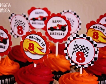 Peut inclure: Des cupcakes avec un glaçage rouge et orange, surmontés de décorations. Les décorations présentent des voitures de course, des drapeaux à damiers et les inscriptions "Happy Birthday" et "Racing to 8".