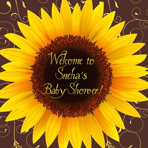 以下が含まれることがあります： 茶色の背景に金色の渦巻き模様が描かれた、黄色のひまわり。ひまわりには「Welcome to Sneha's Baby Shower!」という文字が書かれている