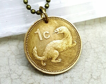 May include: A gold necklace with a 1c Irish coin pendant featuring a weasel. The coin is worn and has a patina.