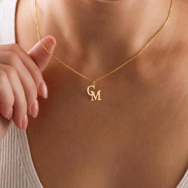 Gold Couple Initial Necklace, personalized double letter jewelry symbolizing love, unity, and connection. The minimalist design brings timeless elegance to your everyday look, making it a perfect gift for couples. This dainty gold necklace glows with subtle sophistication, while the tiny engraved initials add a deeply personal and romantic touch.