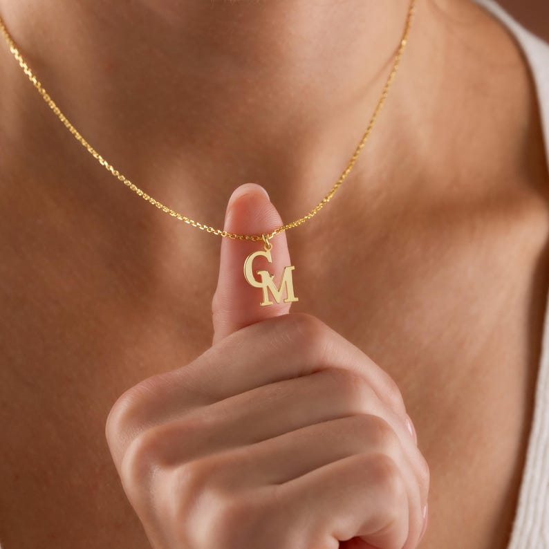 Personalized Gold Couple Initial Necklace, custom double letter jewelry crafted for lovers, partners, or soulmates. The minimalist structure blends modern elegance with emotional depth. This dainty gold piece complements any outfit beautifully, while the tiny initial charms make it a timeless expression of affection and devotion.