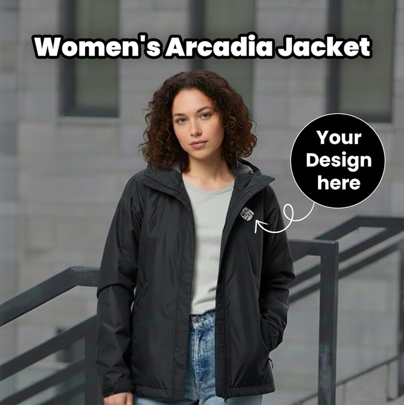 Pu&ograve; includere: Giacca Arcadia nera con cappuccio, indossata sopra una maglietta grigia e jeans blu. La giacca ha un piccolo logo sul petto e il testo "Women's Arcadia Jacket" &egrave; visualizzato in alto. &Egrave; presente anche un cerchio nero con "Your Design here".