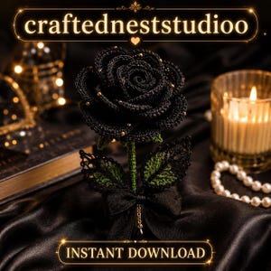 Op de afbeelding: Een zwarte gehaakte roos met gouden accenten, groene bladeren en een zwarte strik. De roos wordt gepresenteerd op een donker satijnen oppervlak. De tekst "craftedneststudioo" en "INSTANT DOWNLOAD" zijn zichtbaar.