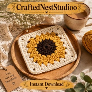 May include: A crocheted sunflower square in yellow, brown, and cream colors sits on a wooden plate. The square is centered on the plate, with a cup of coffee and a ball of yarn in the background. The text "CraftedNestStudioo" and "Instant Download" are visible.