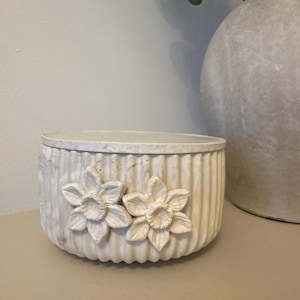 May include: A trio of ceramic mugs with a speckled, matte finish in light blue, cream, and grey. The mugs have a simple, modern design with a rounded shape and a comfortable handle.