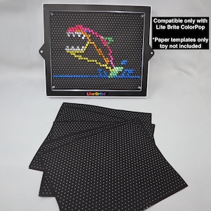 May include: A Lite-Brite toy with a colorful dolphin design. The black screen has a grid of holes for inserting pegs. The image includes paper templates and the text: "Compatible only with Lite Brite ColorPop" and "Paper templates only toy not included."