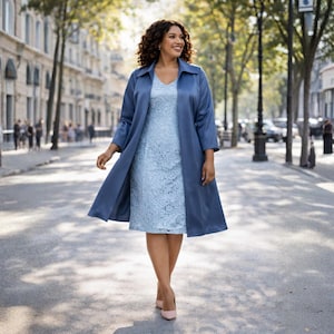 Può includere: Una donna indossa un abito in pizzo azzurro con un cappotto lungo abbinato. Il cappotto ha un colletto e maniche a tre quarti. Indossa tacchi rosa chiaro e cammina per una via cittadina.